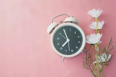 عکس ساعت زنگ دار قدیمی بر روی پس زمینه چوبی با جزئیات زیبا