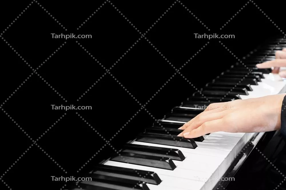 عکس نزدیک به تصویر دست نوازنده ای که در حال نواختن پیانو است