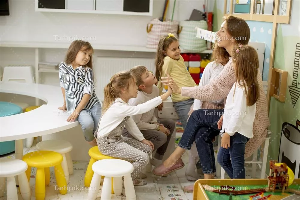 عکس کودکان پیش دبستانی با معلم خود در حال همکاری و یادگیری