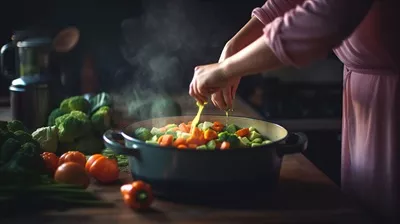 عکس زنی که در حال آماده سازی سبزیجات برای پخت و پز در آشپزخانه است