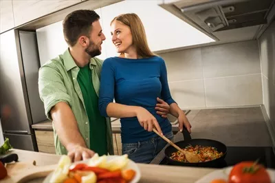 عکس زوج جوان در حال آشپزی با همدیگر و لذت بردن از لحظات شیرین