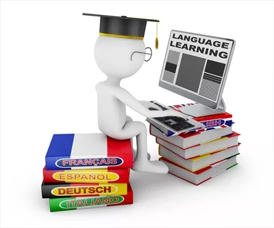 عکس مردی در حال یادگیری زبان با کتاب و لپ تاپ در محیطی آرام