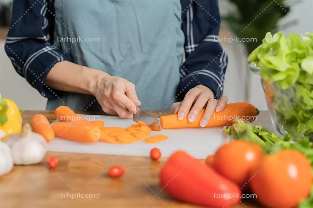 عکس زنی آسیایی در حال آماده سازی مواد غذایی سالم در آشپزخانه