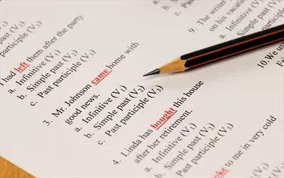 عکس آزمون زبان انگلیسی بر روی میز با مداد و لوازم تحریر