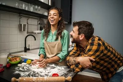 عکس زوج خوشحال و چندملیتی در حال آشپزی با همدیگر