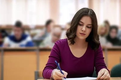 عکس دختر نشسته در آمفی تئاتر و گفتگو با همکارانش در یک محیط دوستانه