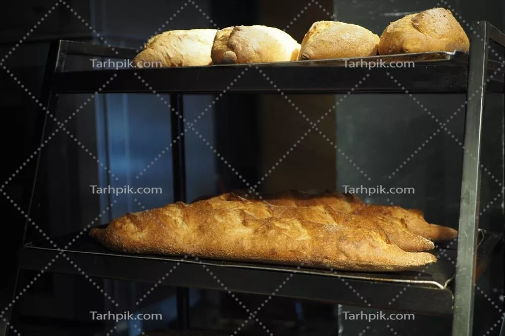عکس نان تازه پخته شده بر روی قفسه ها آماده فروش در نانوایی
