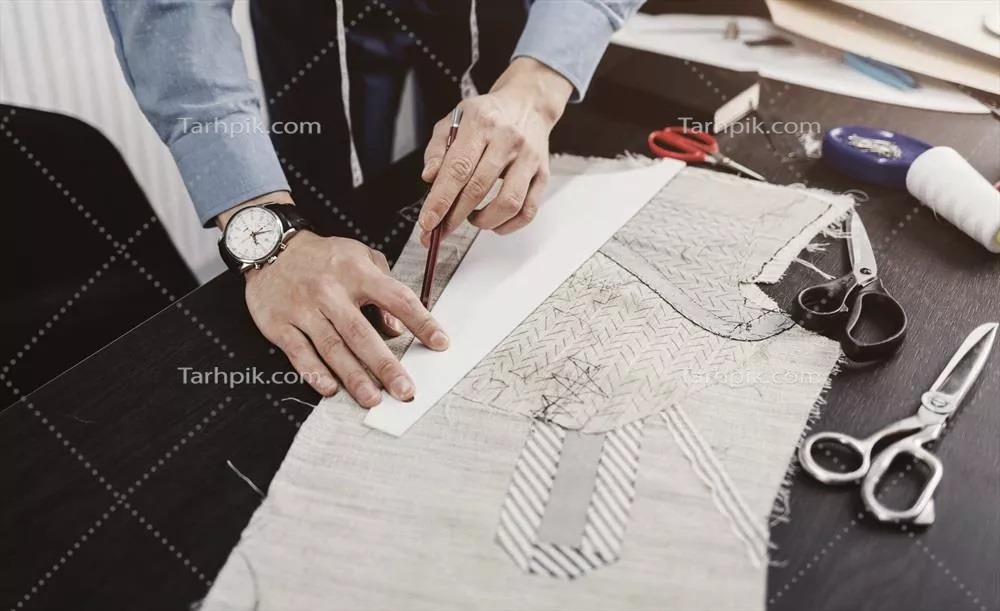 عکس میز کار خیاطی با پارچه و ابزارهای دوخت و دوز