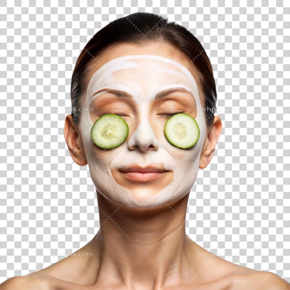 عکس دوربری زنی در حال لذت بردن از روتین مراقبت از پوست صبحگاهی با ماسک صورت و خیار