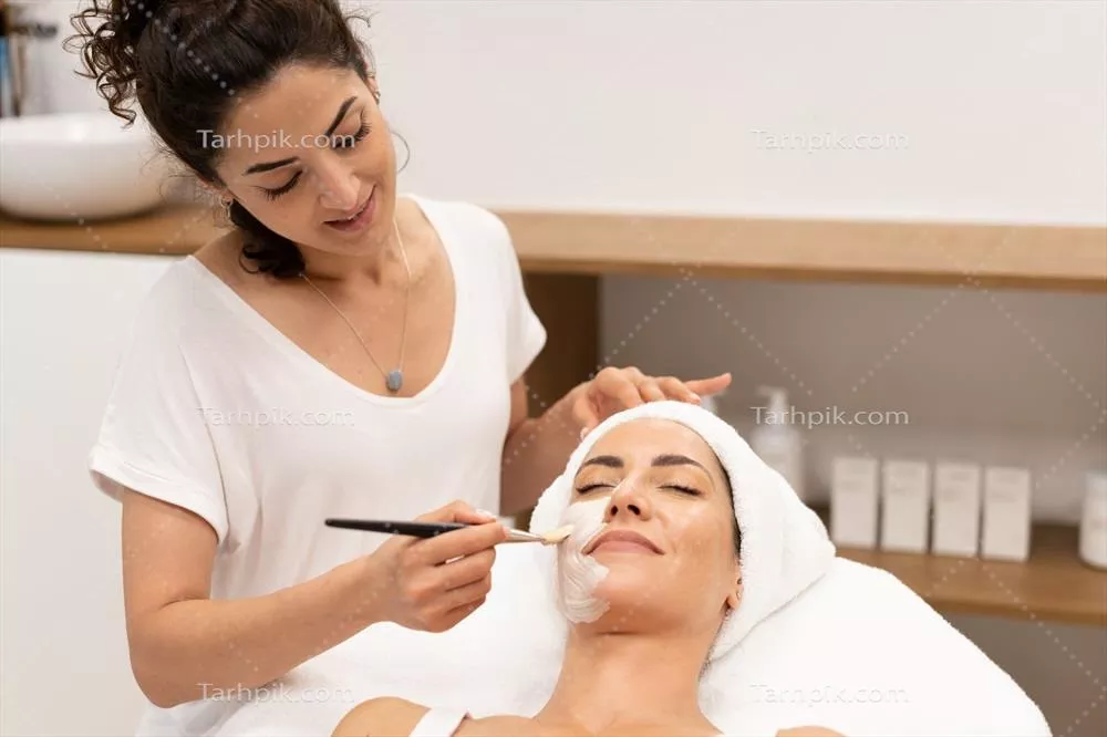 عکس متخصص زیبایی در حال اعمال ماسک صورت بر روی مشتری