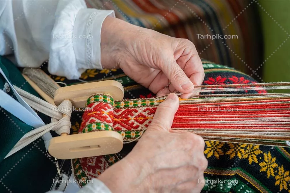 عکس زنی در حال کار بر روی دار قالی، نمایانگر هنر سنتی و قومی بالتیک