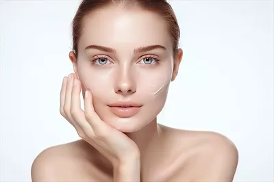 عکس زنی زیبا که با دستانش صورتش را لمس می کند و به زیبایی و سلامت خود می بالد