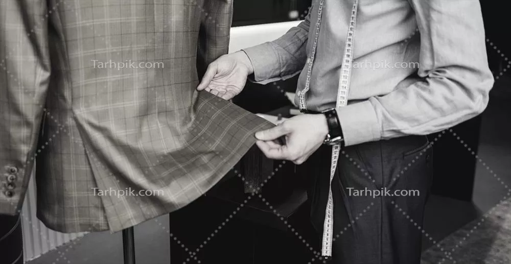 عکس تصویری از یک خیاط مرد که با نوار اندازه گیری مشغول کار است