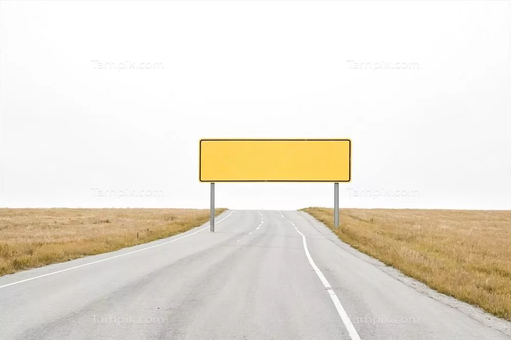 عکس تابلوی زرد خالی در جاده ای ساکت و بی حرکت