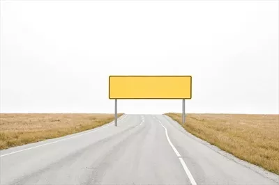 عکس تابلوی زرد خالی در جاده ای ساکت و بی حرکت