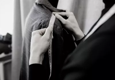 عکس خیاط مرد در حال طراحی و دوخت کت و شلوار مجلسی یا عروسی