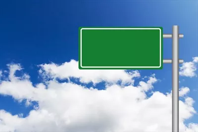 عکس تابلوی راهنمای سبز رنگ در جاده با طراحی زیبا و جذاب