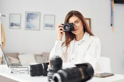 عکس عکاس زن در لباس های راحتی در حال کار در محیط داخلی در طول روز