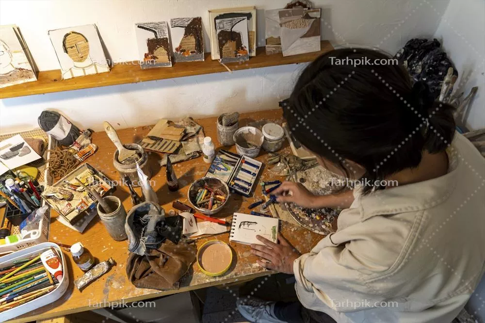 عکس فضای کار هنرمند زن هیسپانیک با آثار نقاشی روغنی در مکزیک