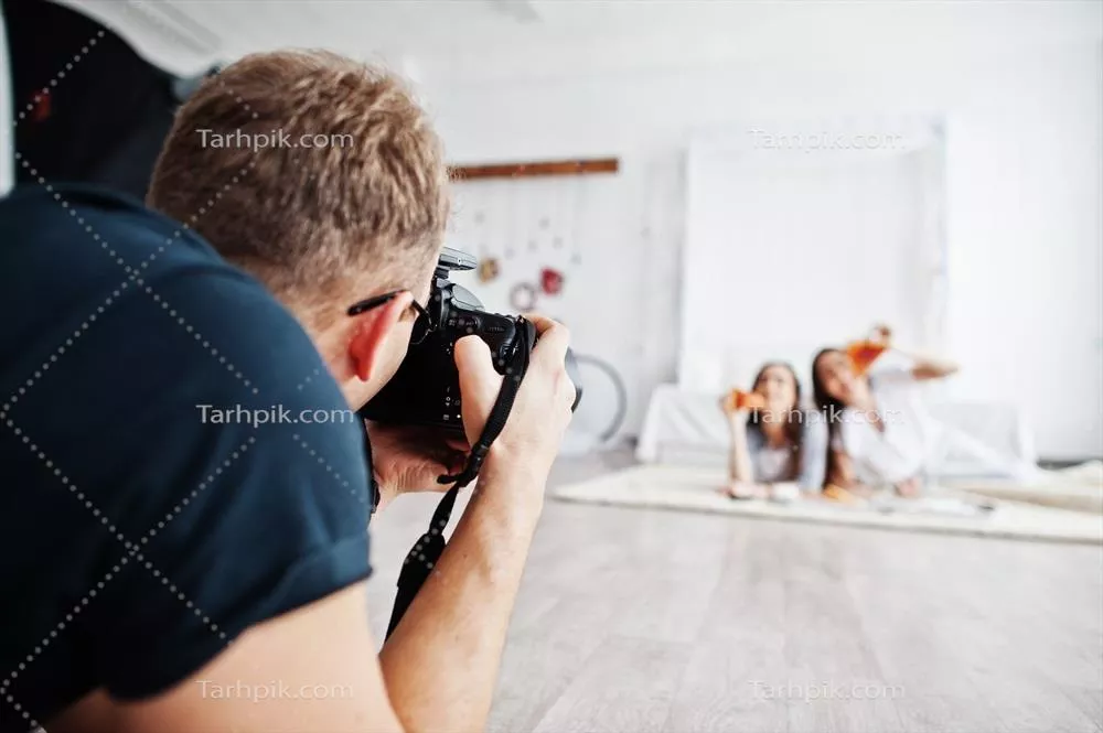 عکس عکاسی حرفه ای از دو دختر دوقلو در استودیو در حال خوردن پیتزا