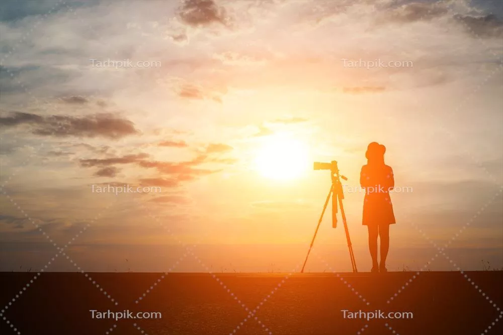 عکس تصویری زیبا از یک عکاس در حال عکاسی در غروب آفتاب