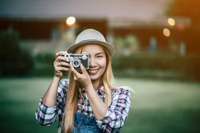 عکس زنی جوان با دوربین فیلم قدیمی در حال ژست گرفتن و ثبت لحظه ها