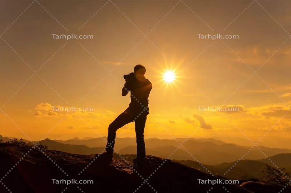 عکس تصویری زیبا از عکاس در حال ثبت لحظه غروب در کوهستان