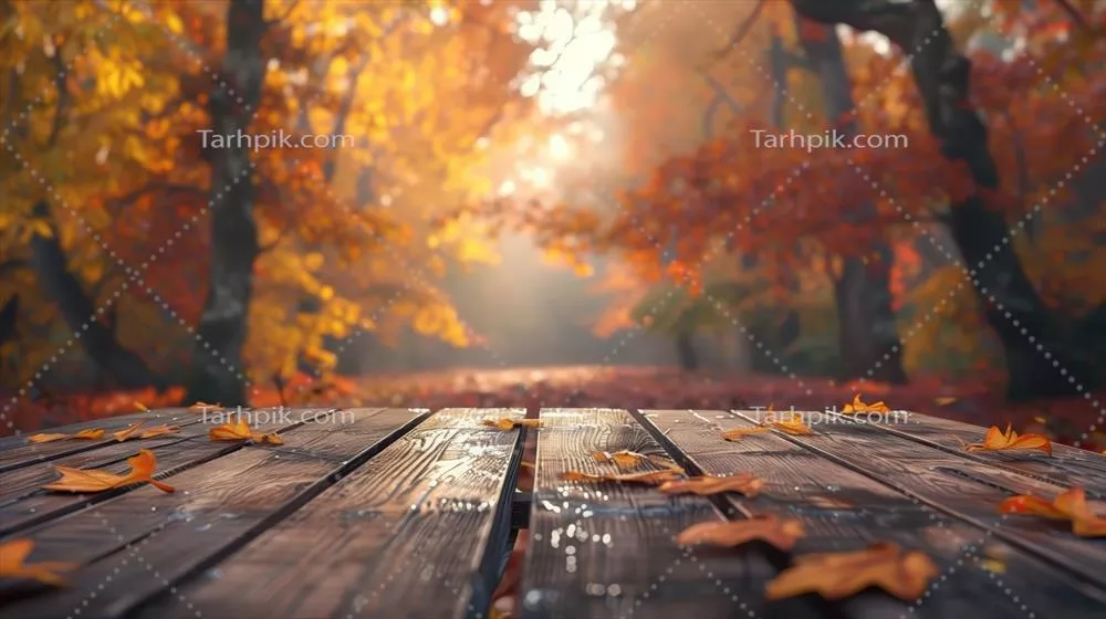 عکس میز چوبی زیبا در پس زمینه ای از پاییز با برگ های در حال سقوط