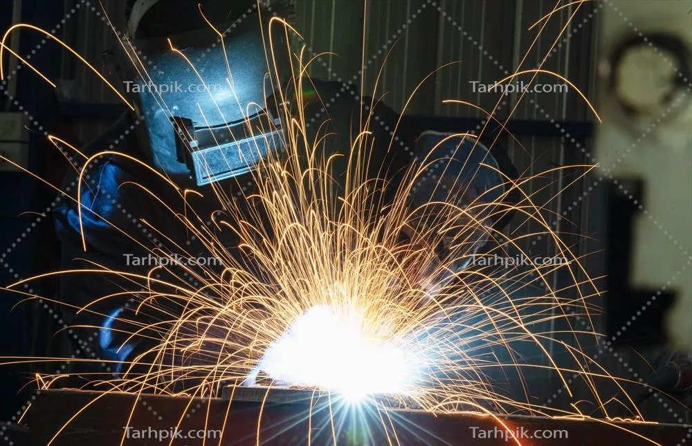 عکس کارگران صنعتی در کارخانه جوشکاری سازه های فولادی در حال فعالیت