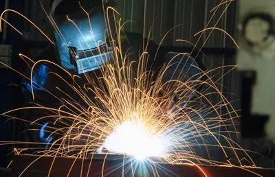 عکس کارگران صنعتی در کارخانه جوشکاری سازه های فولادی در حال فعالیت