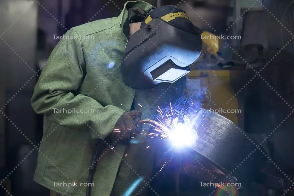 عکس کارگری که در حال جوشکاری با کلاه ایمنی محافظتی است
