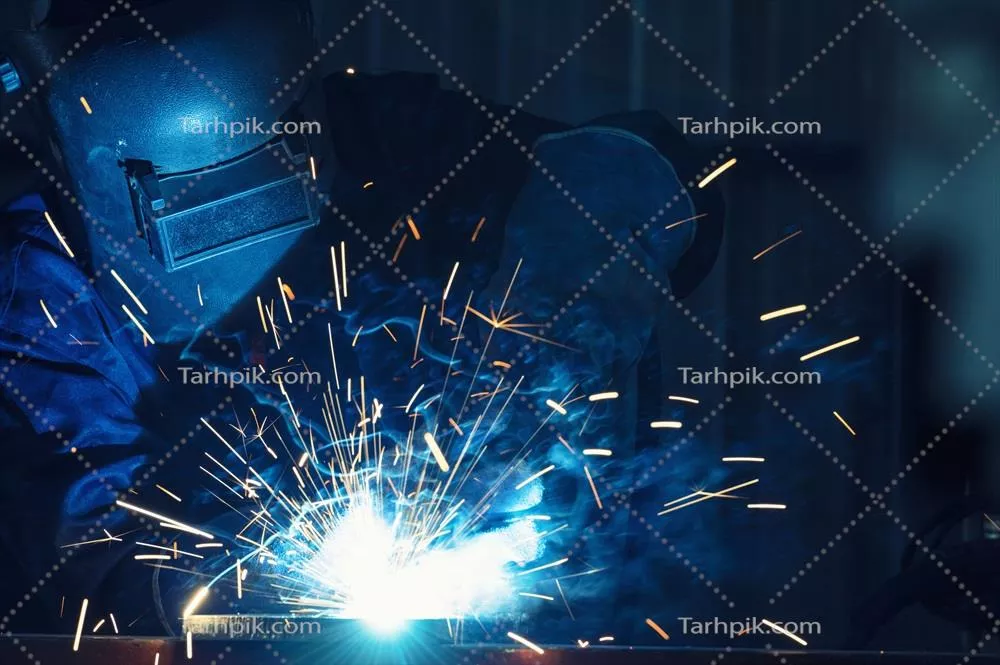 عکس کارگران صنعتی در کارخانه جوشکاری سازه های فولادی در حال کار