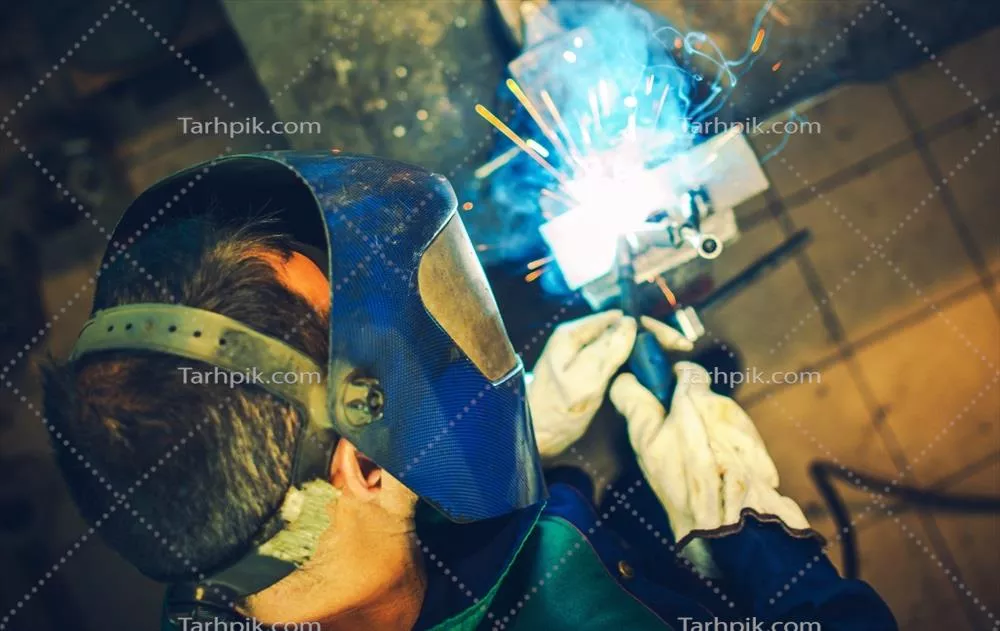 عکس تصویری از یک جوشکار در حال انجام کار جوشکاری با دقت و مهارت