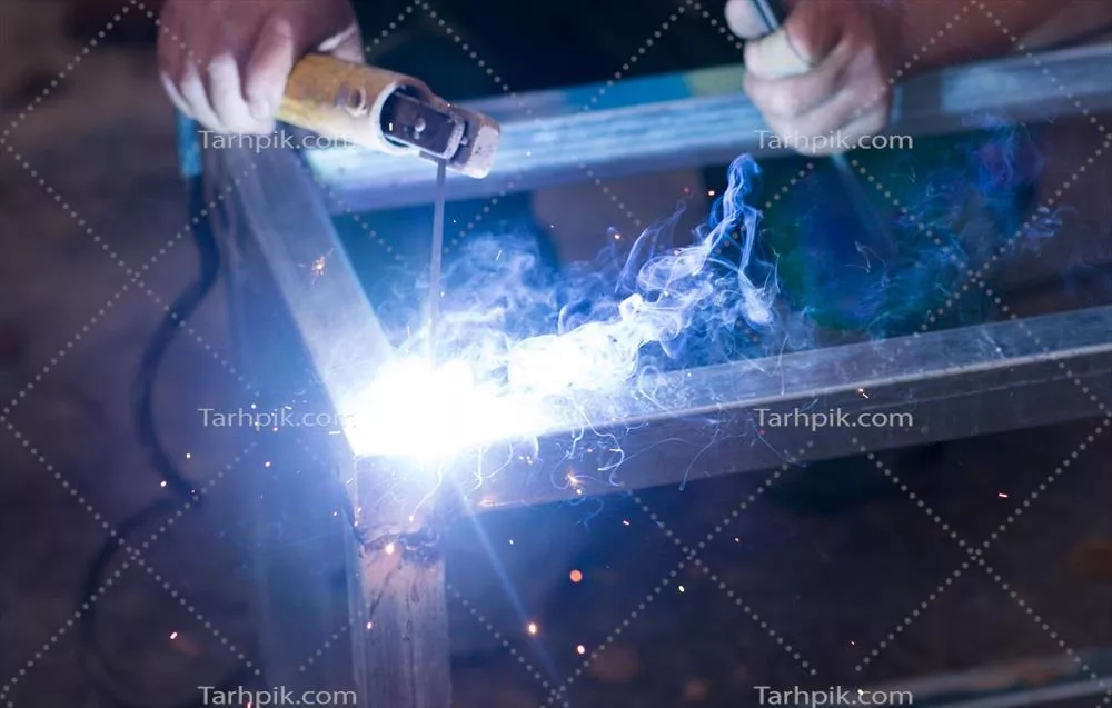 عکس فرایند جوشکاری قوس الکتریکی بر روی فولاد در محل کار