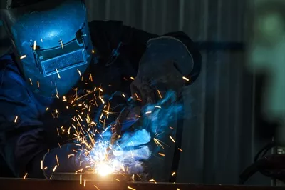 عکس کارگران صنعتی در کارخانه جوشکاری سازه های فولادی مشغول به کار هستند