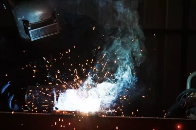 عکس کارگران صنعتی در کارخانه جوشکاری سازه های فولادی در حال کار
