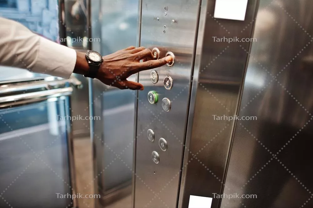 عکس نمای نزدیک از دست مرد آفریقایی-آمریکایی در حال فشار دادن دکمه آسانسور