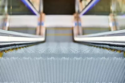 عکس تصویری از پله برقی در یک مرکز خرید شلوغ و مدرن
