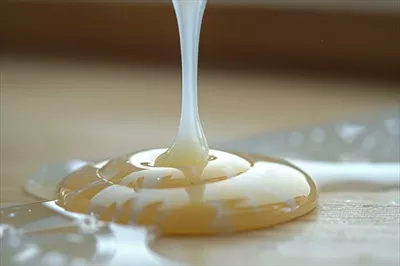 عکس چکیدن طلای مایع بر روی سطح چوبی در نور طبیعی گرم و دلنشین