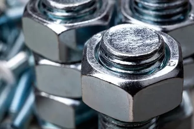 عکس نمای نزدیک از مهره های فولادی که بر روی پیچ سوار شده اند