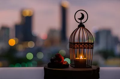 عکس فانوس هایی با نماد ماه و خرما بر روی سینی چوبی در جشن رمضان