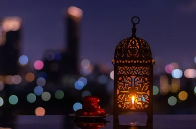 عکس چراغ های زیبا و بشقاب کوچک خرما در شب رمضان با نورهای شهر