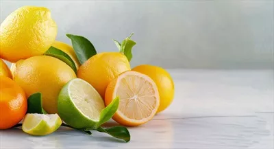 عکس نمایش میوه های تازه و مرکبات بر روی پس زمینه ای روشن با برگ های سبز