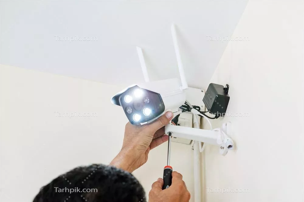 عکس نصب دوربین مداربسته بی سیم توسط تکنسین ها در یک محیط کاری