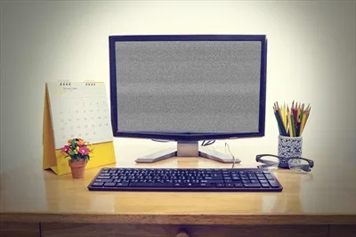 عکس تصویری زیبا از مانیتور کامپیوتر روی میز چوبی با پس زمینه دلنشین
