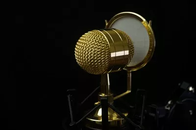 عکس میکروفن کاندنسر طلایی با پس زمینه سیاه و فوکوس انتخابی