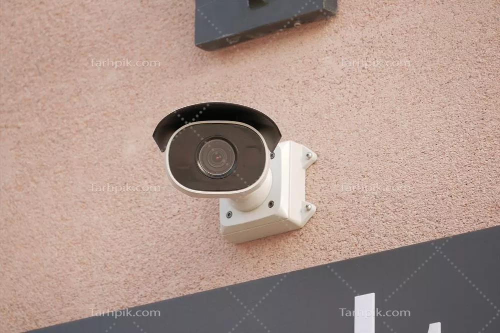 عکس دوربین مداربسته امنیتی در حال کار بر روی دیوار