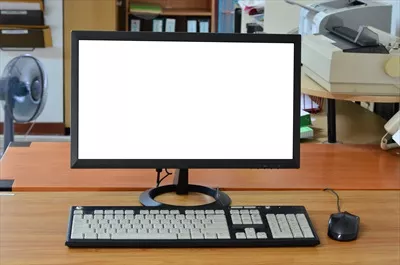 عکس کامپیوتر قدیمی روی میز کار با صفحه نمایش خالی در اتاق اداری