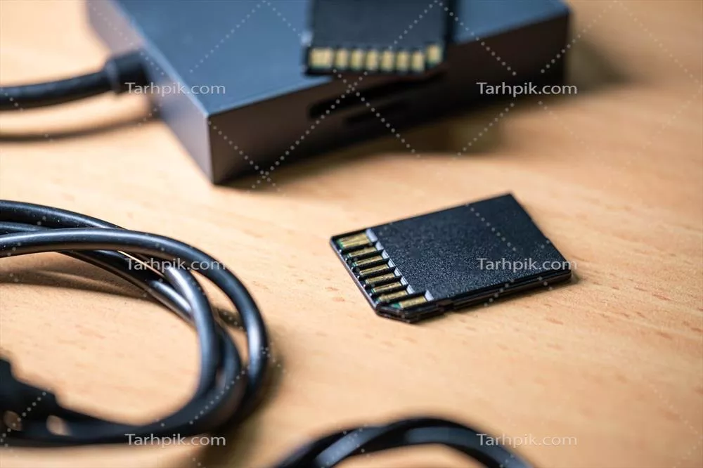 عکس کارت های حافظه SD و خواننده کارت بر روی سطح چوبی