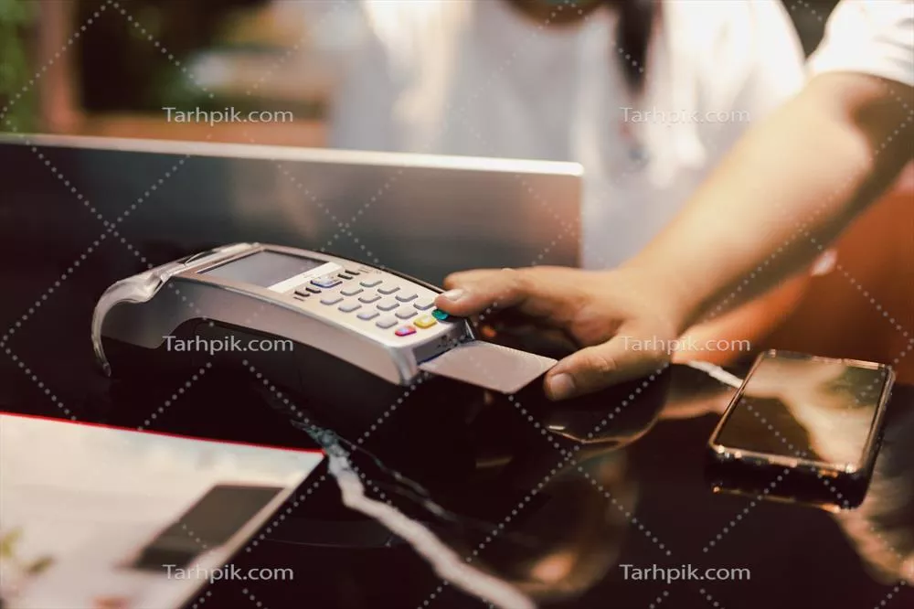 عکس مردی که از دستگاه کارتخوان برای وارد کردن رمز عبور استفاده می کند